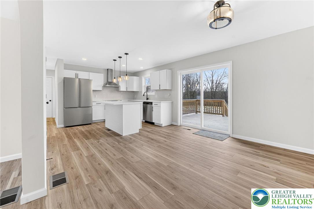 5693 Neola Road Stroudsburg, PA 18360 - Photo 7 of 30 a view of a kitchen with a sink and dishwasher a refrigerator with wooden floor