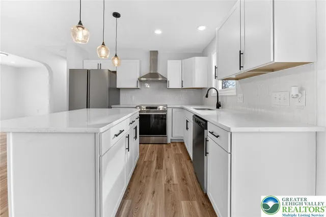 a kitchen with a sink a counter top space stainless steel appliances and cabinets