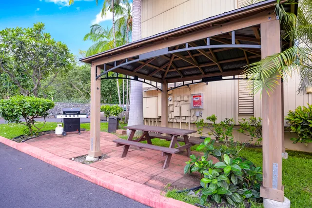 a view of a backyard with table and chairs under an umbrella