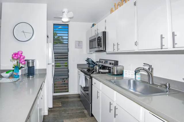 a kitchen with stainless steel appliances granite countertop a sink dishwasher and cabinets with wooden floor