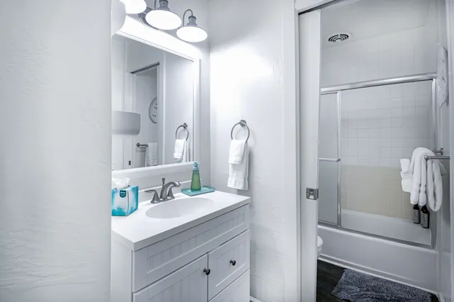 a bathroom with a tub sink vanity and mirror