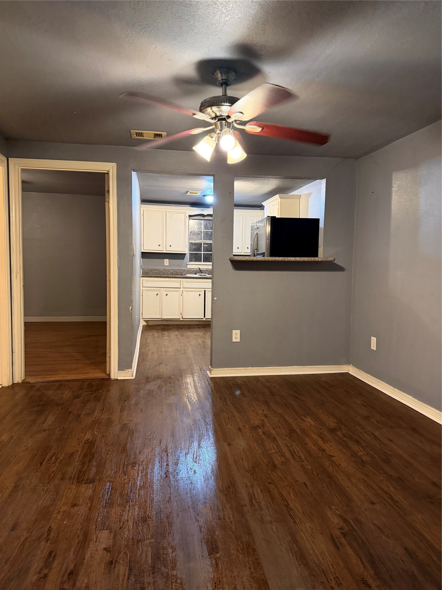 7928 Buchanan Street Houston, TX 77029 - Photo 17 of 25 a view of a livingroom with wooden floor a ceiling fan and windows
