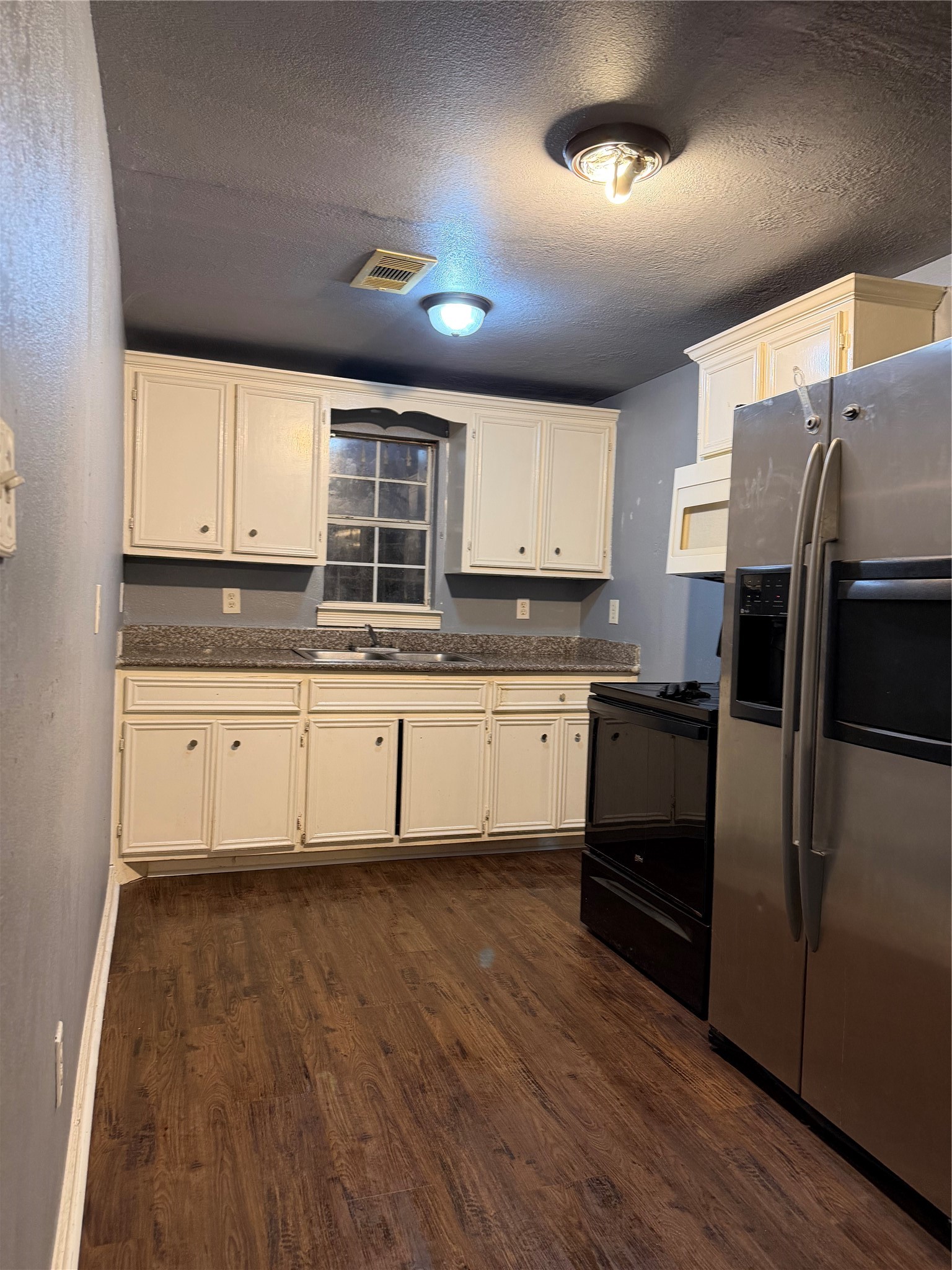 7928 Buchanan Street Houston, TX 77029 - Photo 18 of 25 a kitchen with granite countertop white cabinets and stainless steel appliances