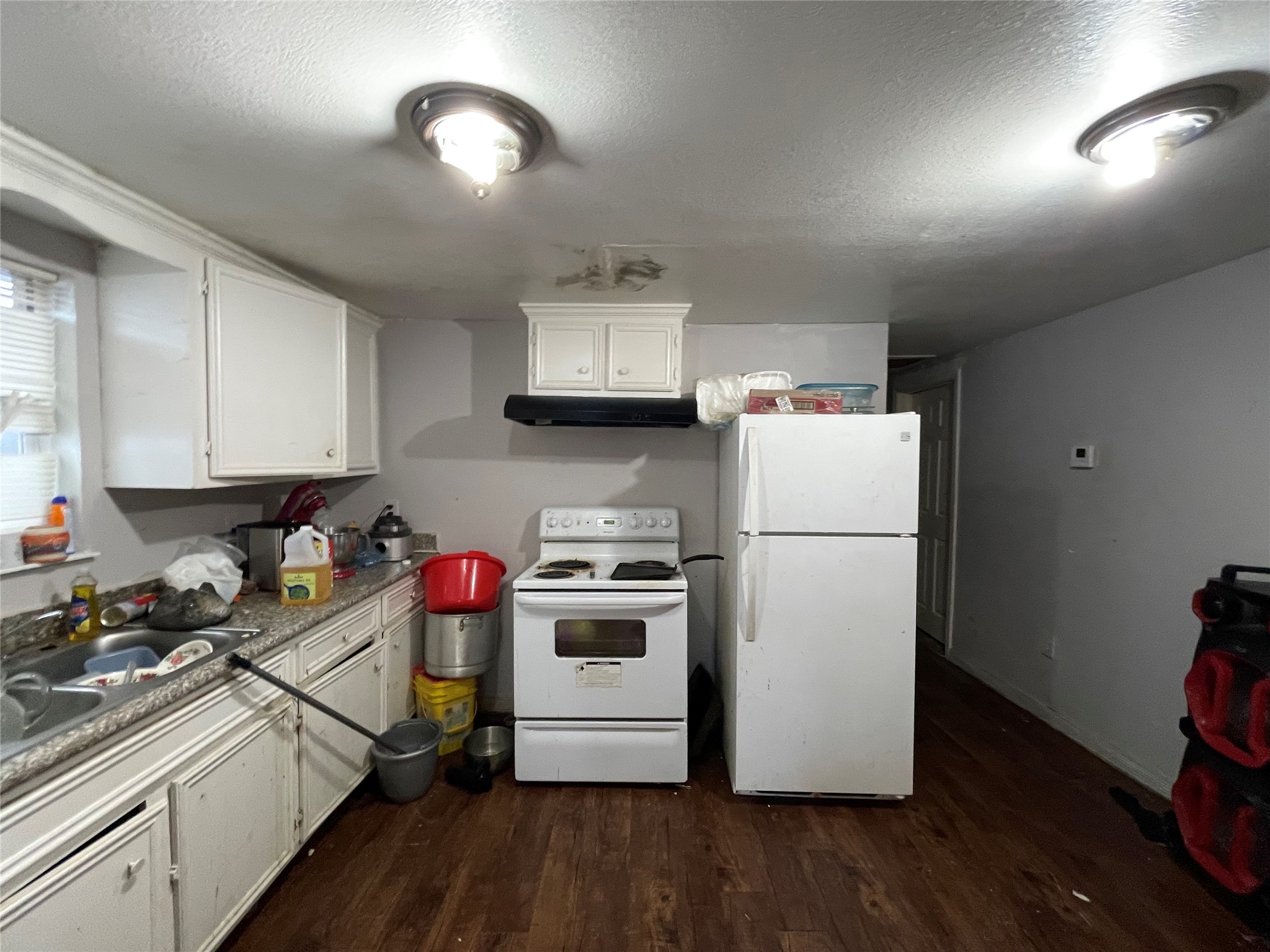 7928 Buchanan Street Houston, TX 77029 - Photo 6 of 25 a kitchen with a refrigerator and a stove top oven