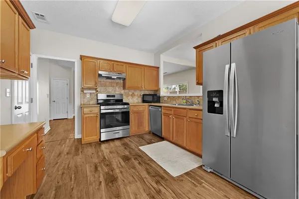 a kitchen with stainless steel appliances a refrigerator and a stove top oven