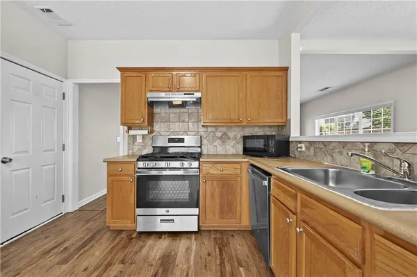a kitchen with stainless steel appliances a stove a sink and a microwave