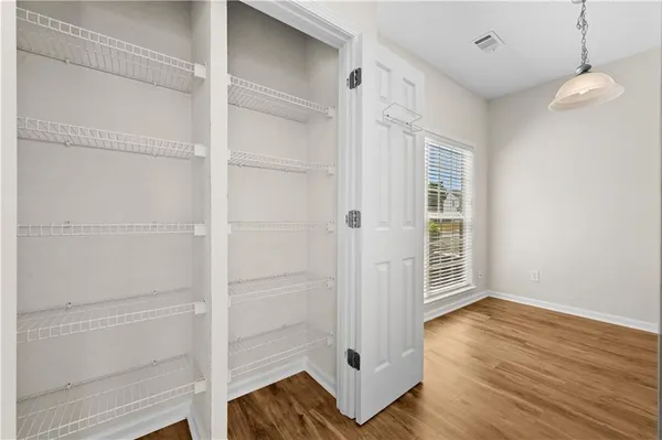 a view of empty room with wooden floor