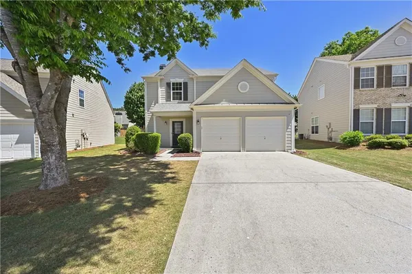 a front view of a house with a yard and garage