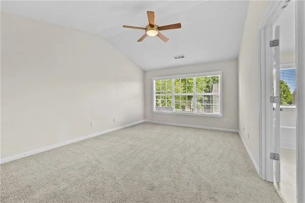 an empty room with a window and a fan