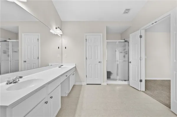 a bathroom with a double vanity sink mirror double and shower