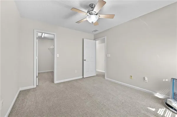 an empty room with a ceiling fan and a window