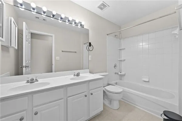a bathroom with a double vanity sink toilet mirror and bathtub