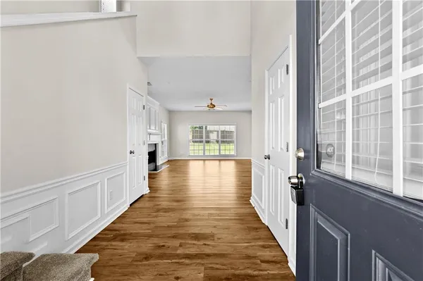 a view of a hallway with wooden floor and windows