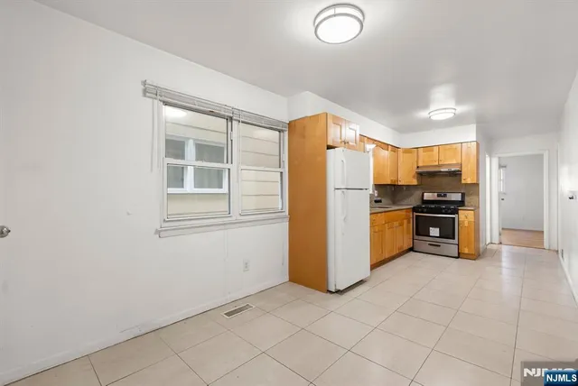 a kitchen with granite countertop a refrigerator and a stove top oven