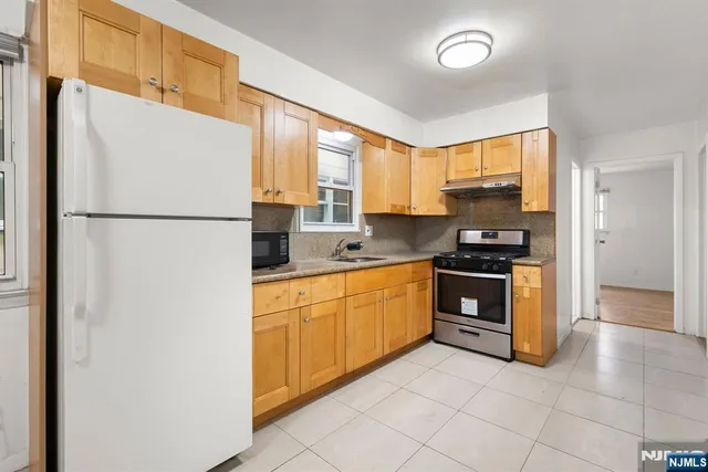 a kitchen with stainless steel appliances a refrigerator sink and cabinets