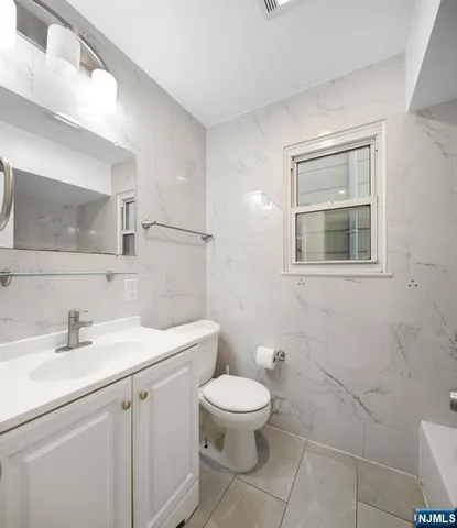 a bathroom with a toilet a sink and mirror