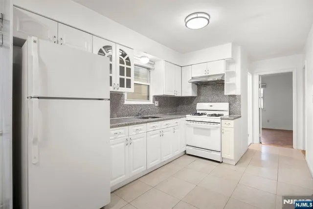 a kitchen with granite countertop cabinets and white appliances