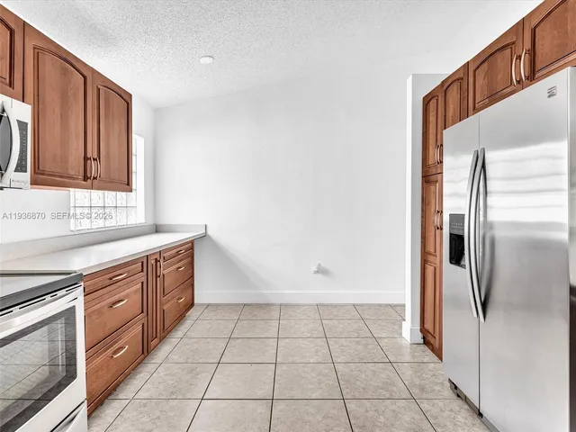 a kitchen with granite countertop a refrigerator and a sink