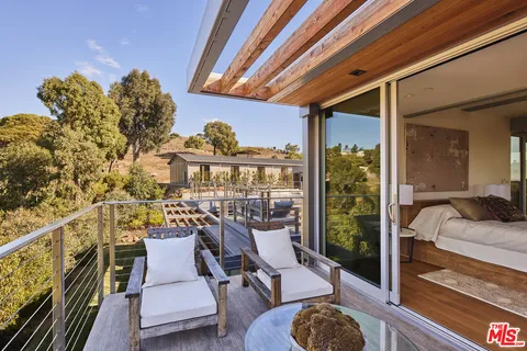 a view of swimming pool with outdoor seating and house in the background