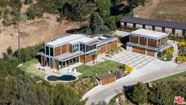 a aerial view of a house with pool and chairs