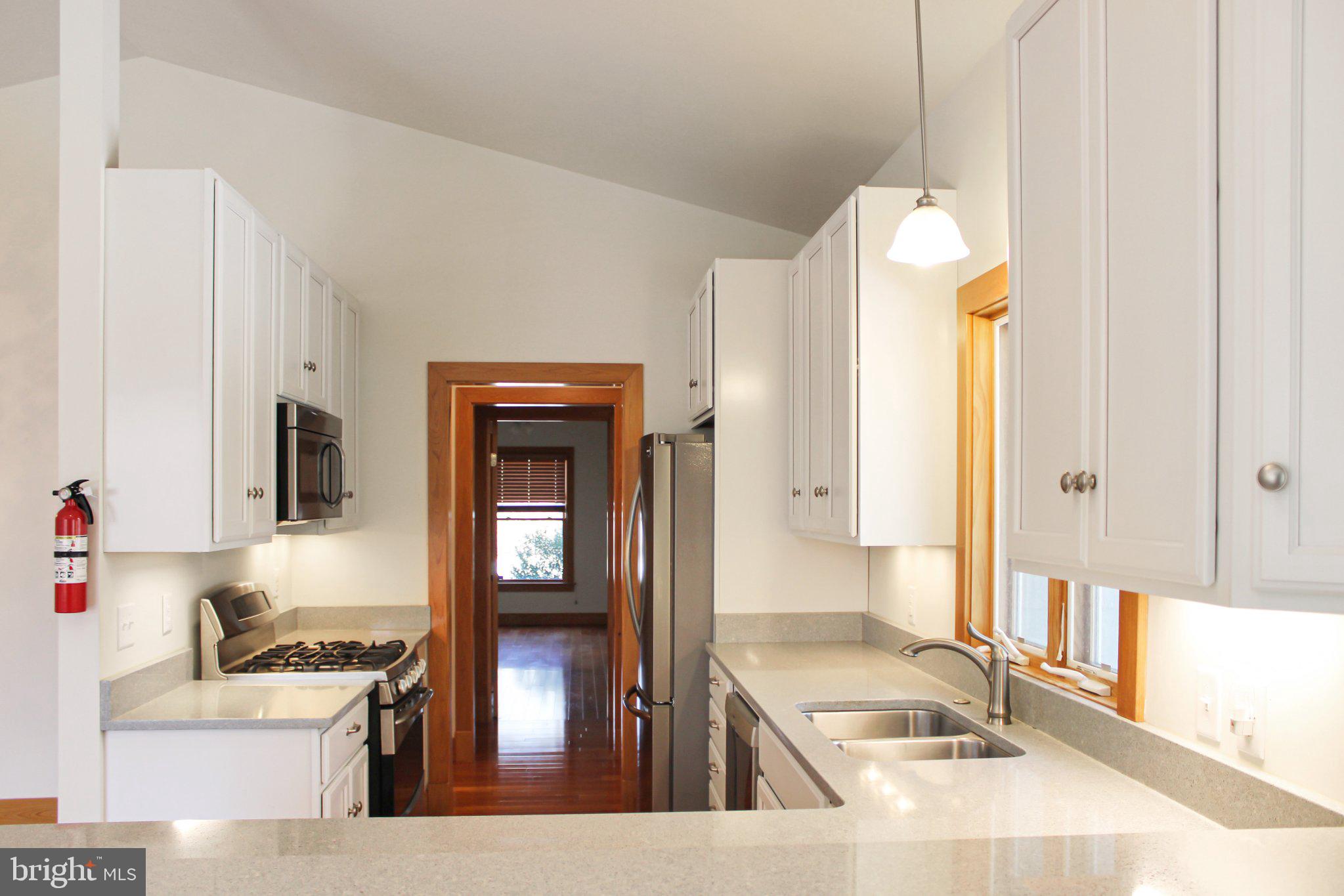522 Unity Place Buckingham, VA 23921 - Photo 3 of 21 a kitchen with granite countertop a stove a sink and a refrigerator with wooden floor