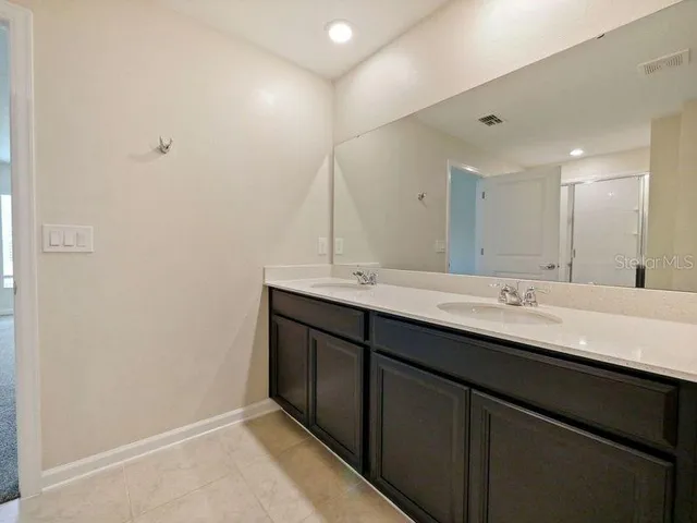 a bathroom with a double vanity sink and a mirror
