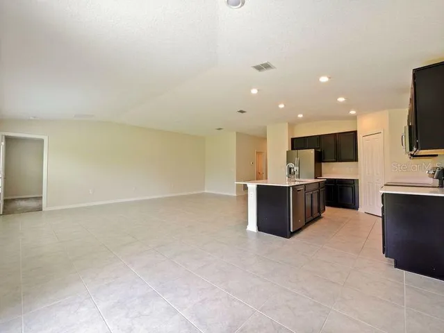 a view of kitchen with kitchen island microwave and cabinets