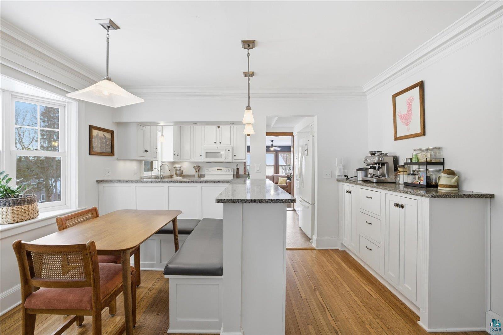 2201 Vermilion Road Duluth, MN 55803 - Photo 11 of 79 Kitchen featuring white cabinetry, light wood-style flooring, pendant lighting, dark stone countertops, and crown molding