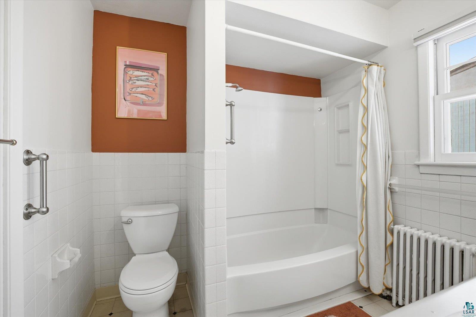 2201 Vermilion Road Duluth, MN 55803 - Photo 26 of 79 Full bath with tile walls, radiator, wainscoting, shower / tub combo with curtain, and light tile patterned floors