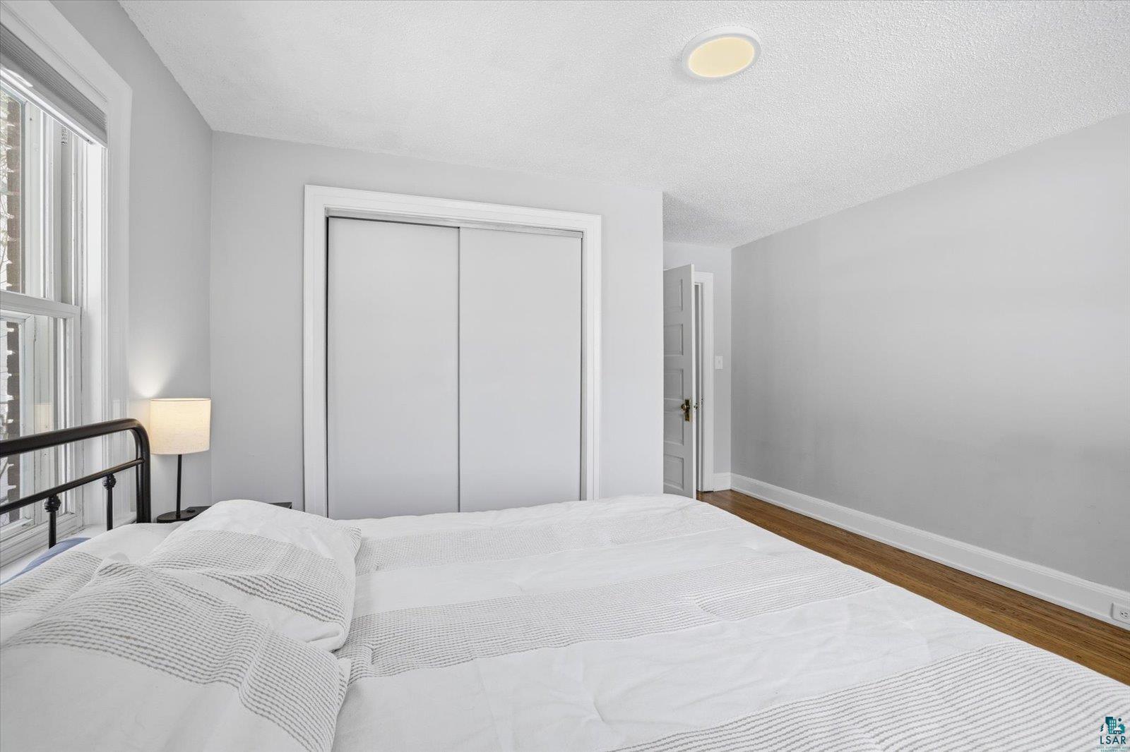 2201 Vermilion Road Duluth, MN 55803 - Photo 28 of 79 Bedroom with a closet, dark wood-type flooring, and a textured ceiling