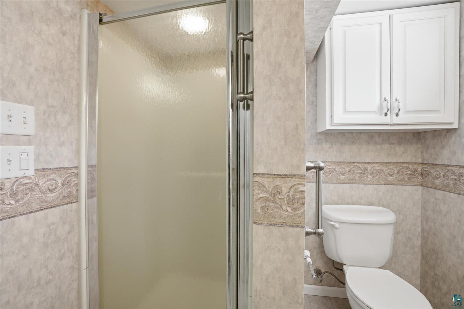 2201 Vermilion Road Duluth, MN 55803 - Photo 46 of 79 Bathroom with a stall shower, wallpapered walls, and wainscoting