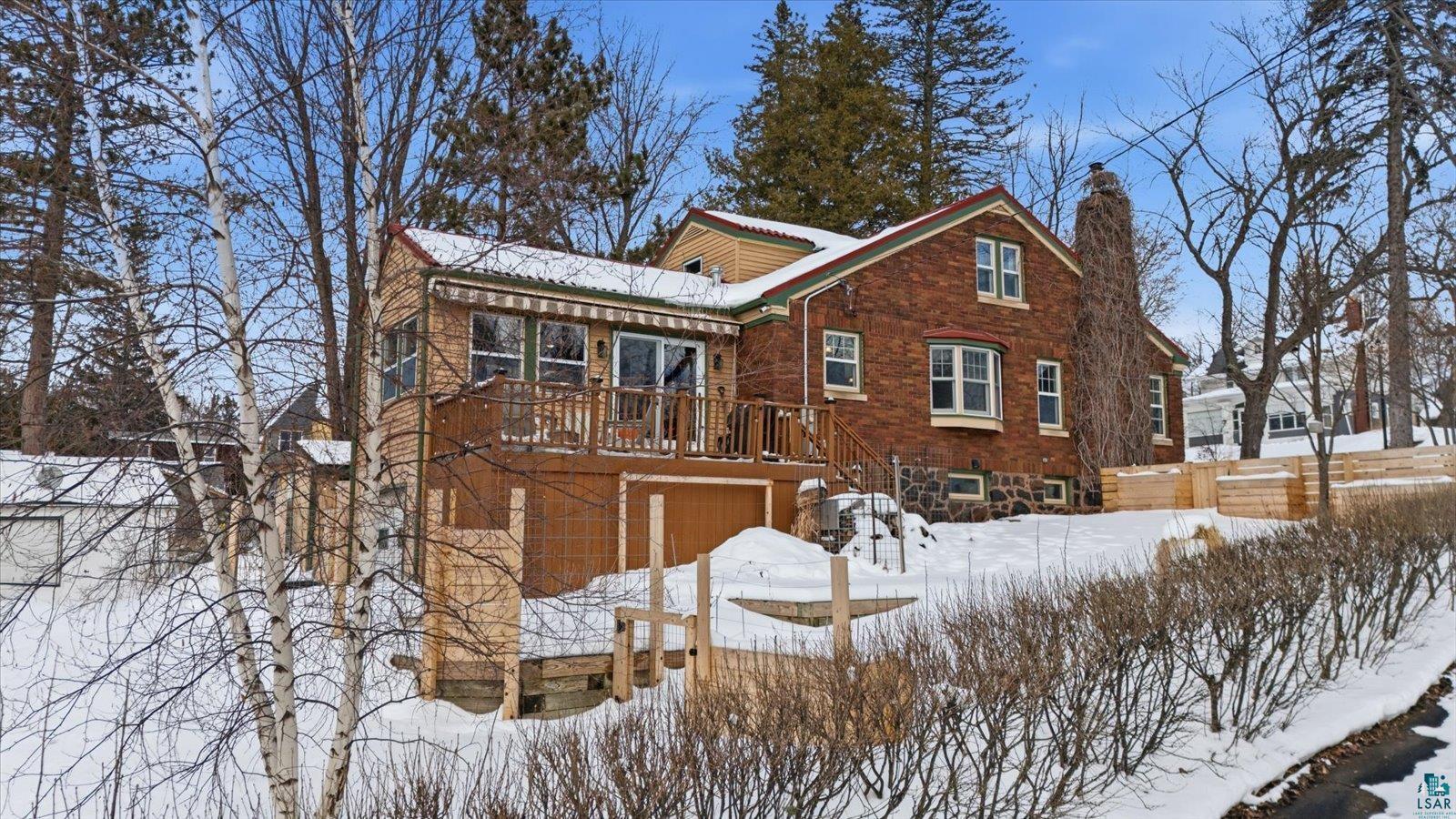 2201 Vermilion Road Duluth, MN 55803 - Photo 62 of 79 Snow covered property with a chimney, a garage, brick siding, and a wooden deck