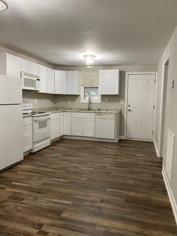 a kitchen with stainless steel appliances granite countertop a stove and white cabinets