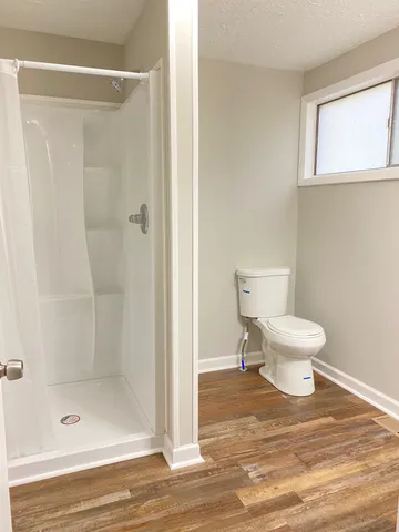 a bathroom with a toilet and a shower