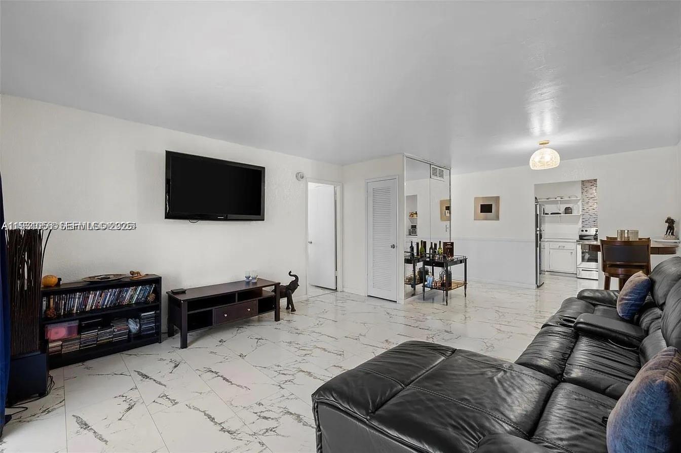 4043 Northwest 16th Street, Unit 201 Lauderhill, FL 33313 - Photo 11 of 22 a living room with furniture and a flat screen tv