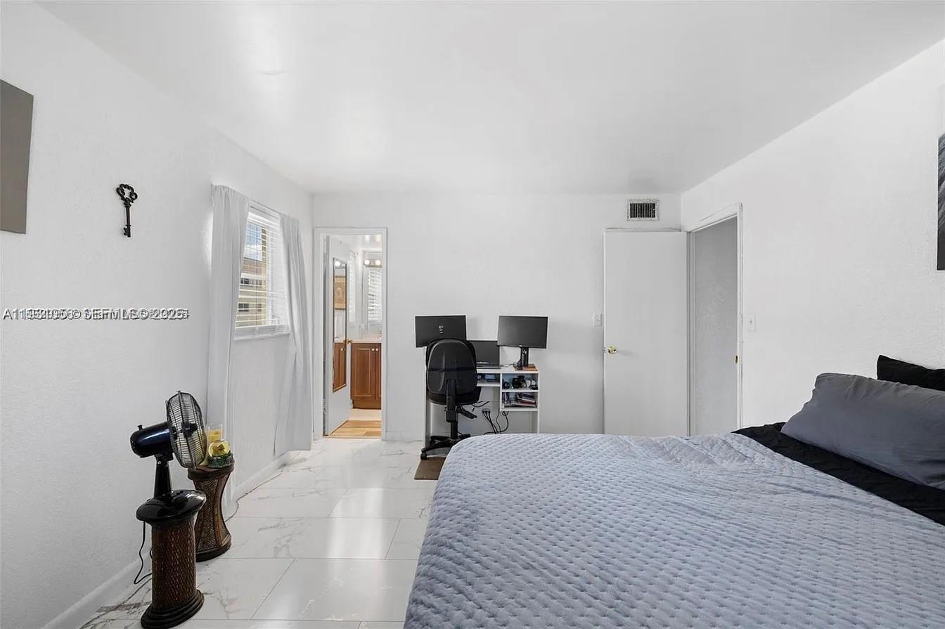 4043 Northwest 16th Street, Unit 201 Lauderhill, FL 33313 - Photo 13 of 22 a bed room with a bed and a television