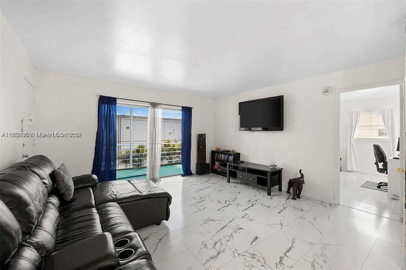 4043 Northwest 16th Street, Unit 201 Lauderhill, FL 33313 - Photo 6 of 22 a living room with furniture and a flat screen tv