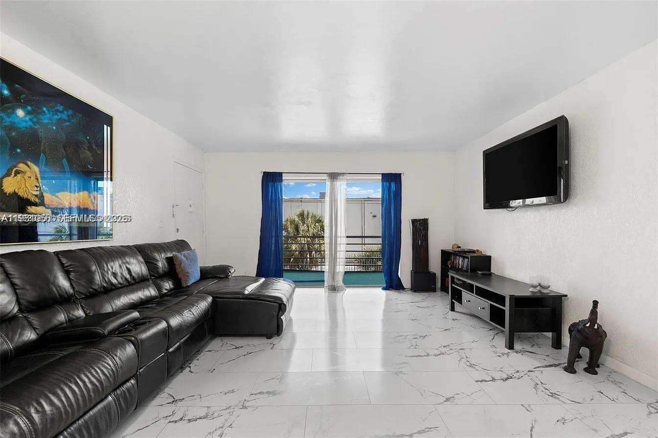 4043 Northwest 16th Street, Unit 201 Lauderhill, FL 33313 - Photo 8 of 22 a living room with furniture and a flat screen tv