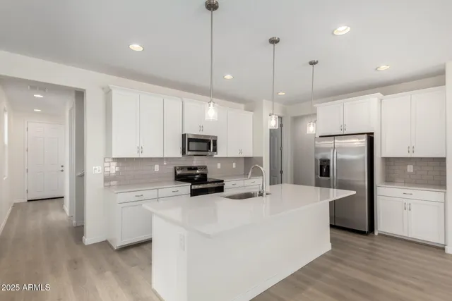 a kitchen with stainless steel appliances a refrigerator sink and microwave