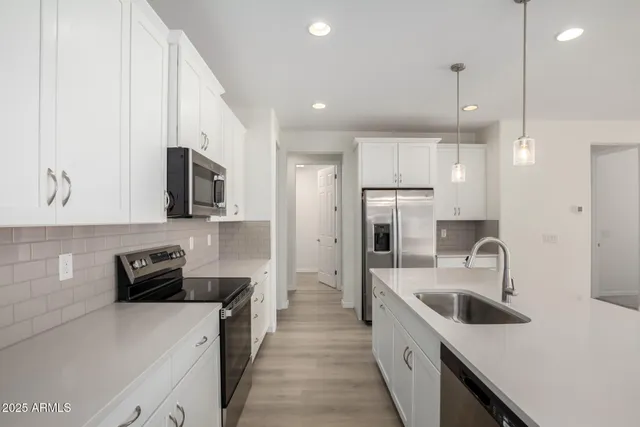 a kitchen with a sink stove top oven and refrigerator