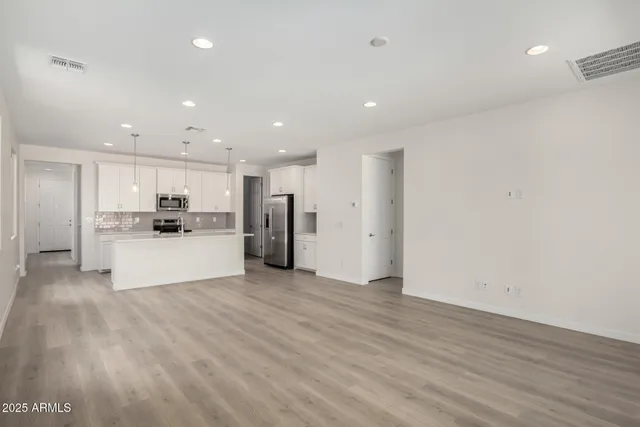 a view of kitchen with kitchen island white cabinets and refrigerator