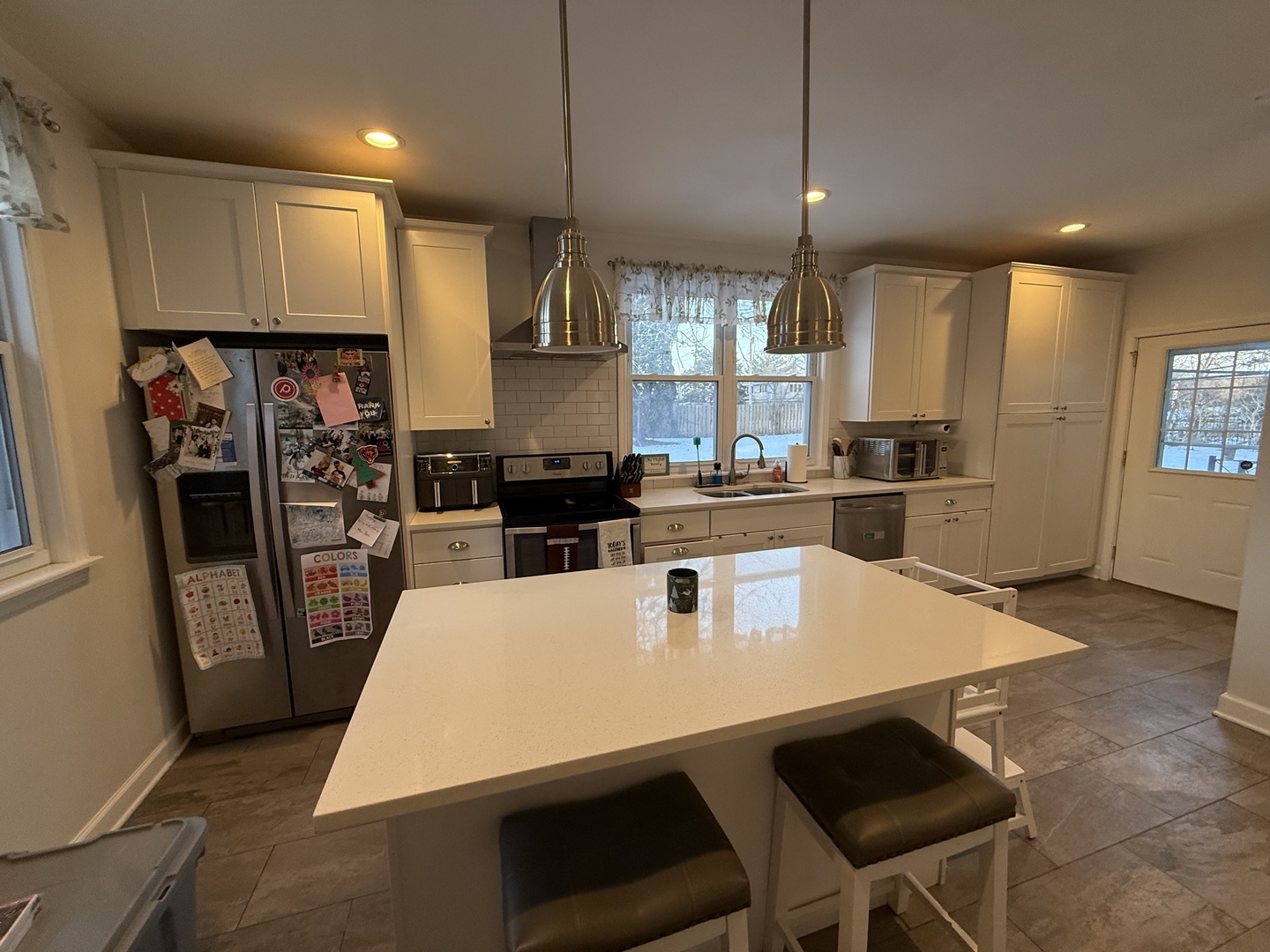 1044 Ellsworth Avenue Addison, IL 60101 - Photo 20 of 45 a kitchen with stainless steel appliances a dining table chairs stove refrigerator and cabinets