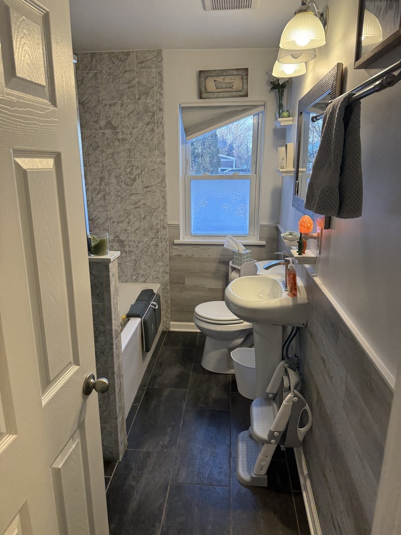 1044 Ellsworth Avenue Addison, IL 60101 - Photo 38 of 45 a bathroom with a sink a toilet and a mirror