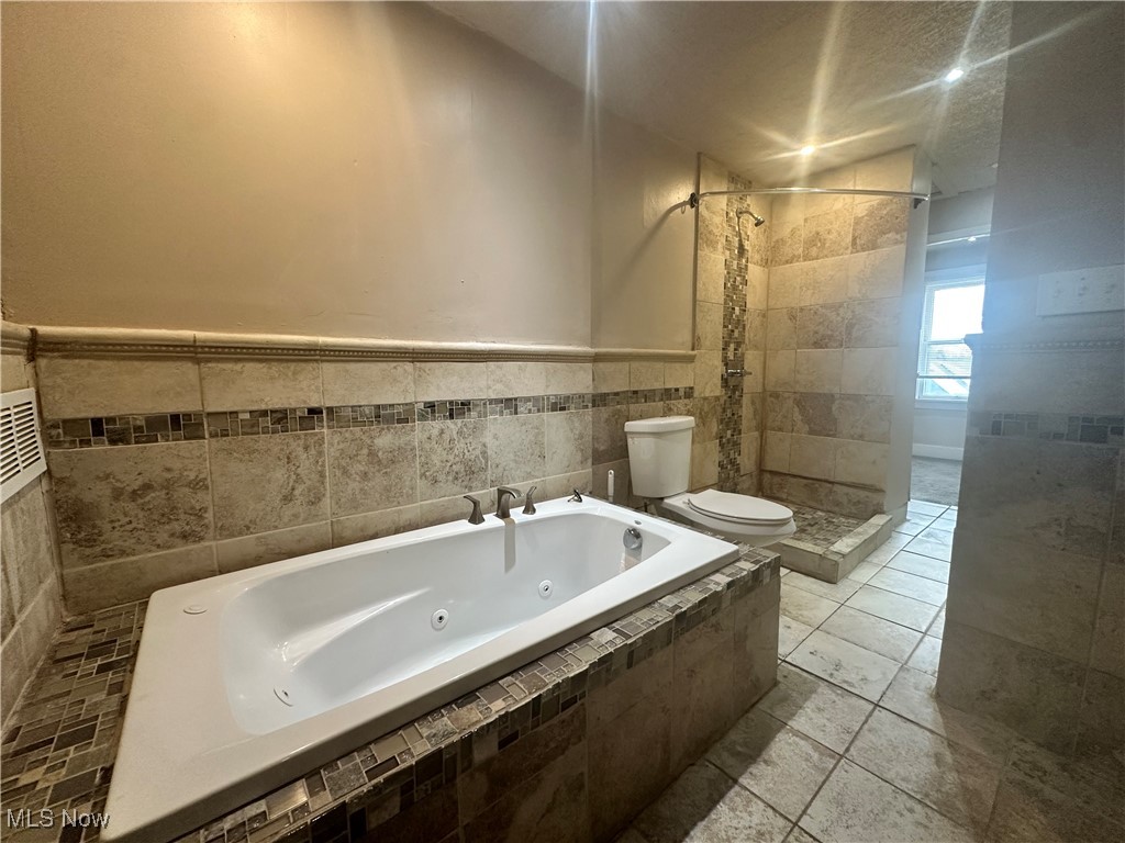 4658 Rockwood Road Cleveland, OH 44125 - Photo 8 of 18 Bathroom featuring a tub with jets, toilet, and a tile shower