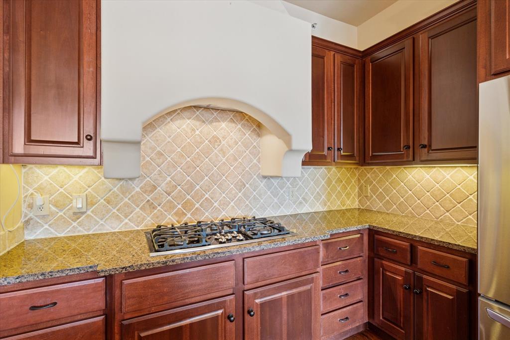 610 Via Ravello, Unit 410 Irving, TX 75039 - Photo 11 of 28 a kitchen with granite countertop a stove and a wooden cabinets