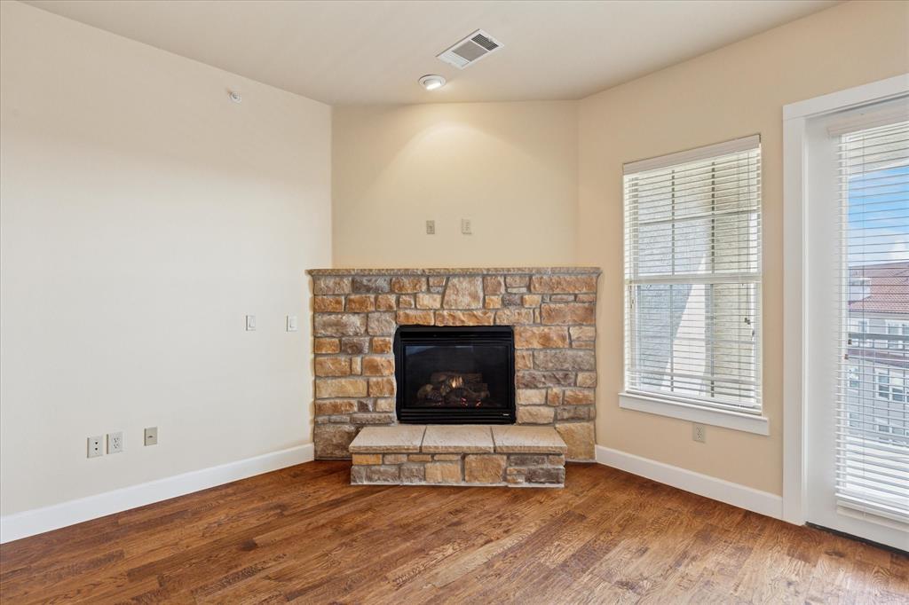 610 Via Ravello, Unit 410 Irving, TX 75039 - Photo 13 of 28 a living room with a fireplace and wooden floor