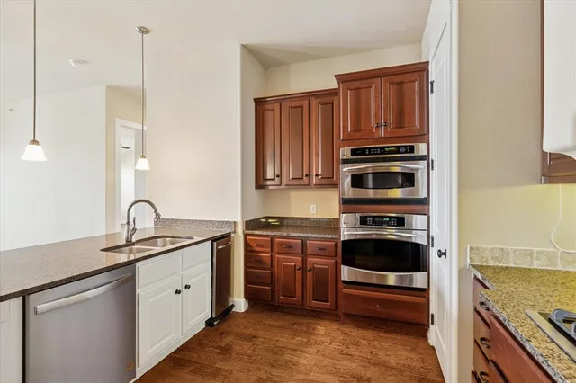 a kitchen with stainless steel appliances a stove a sink a refrigerator and cabinets