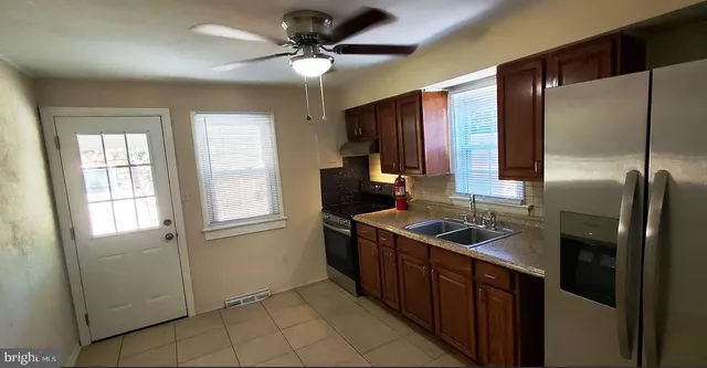 a kitchen that has a sink stainless steel appliances and cabinets