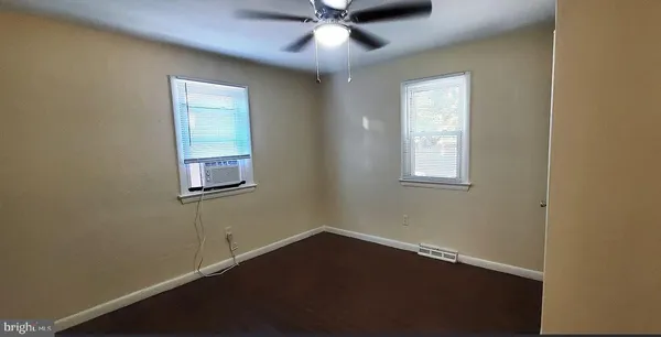 an empty room with a window and a fan