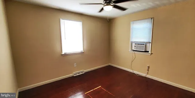 a view of a room with wooden floor and windows